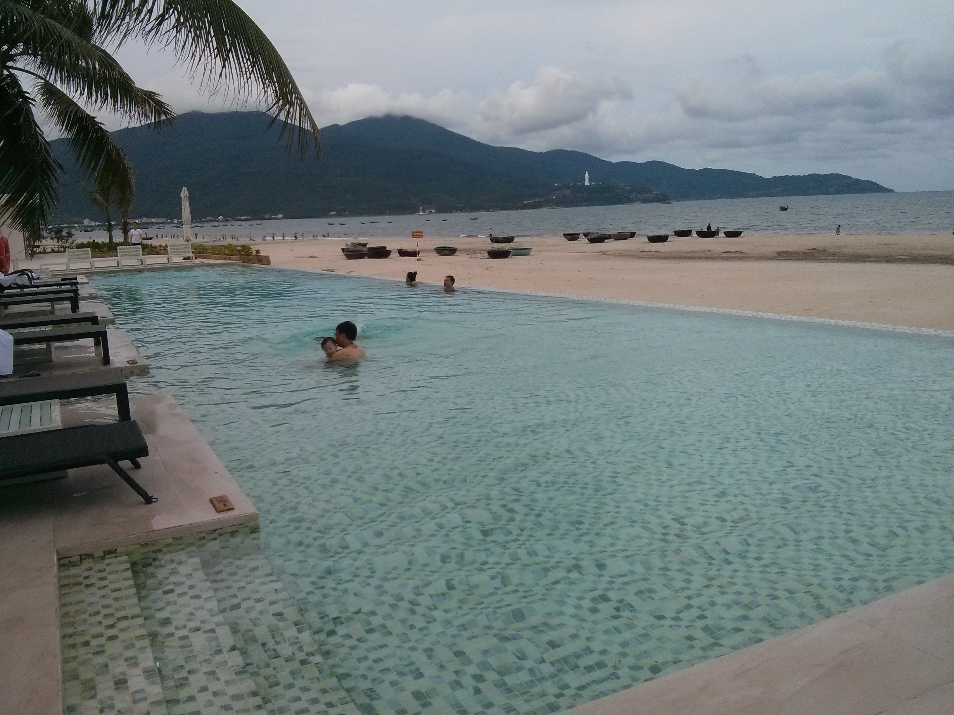 La piscine à débordement et la plage en face de l’hôtel